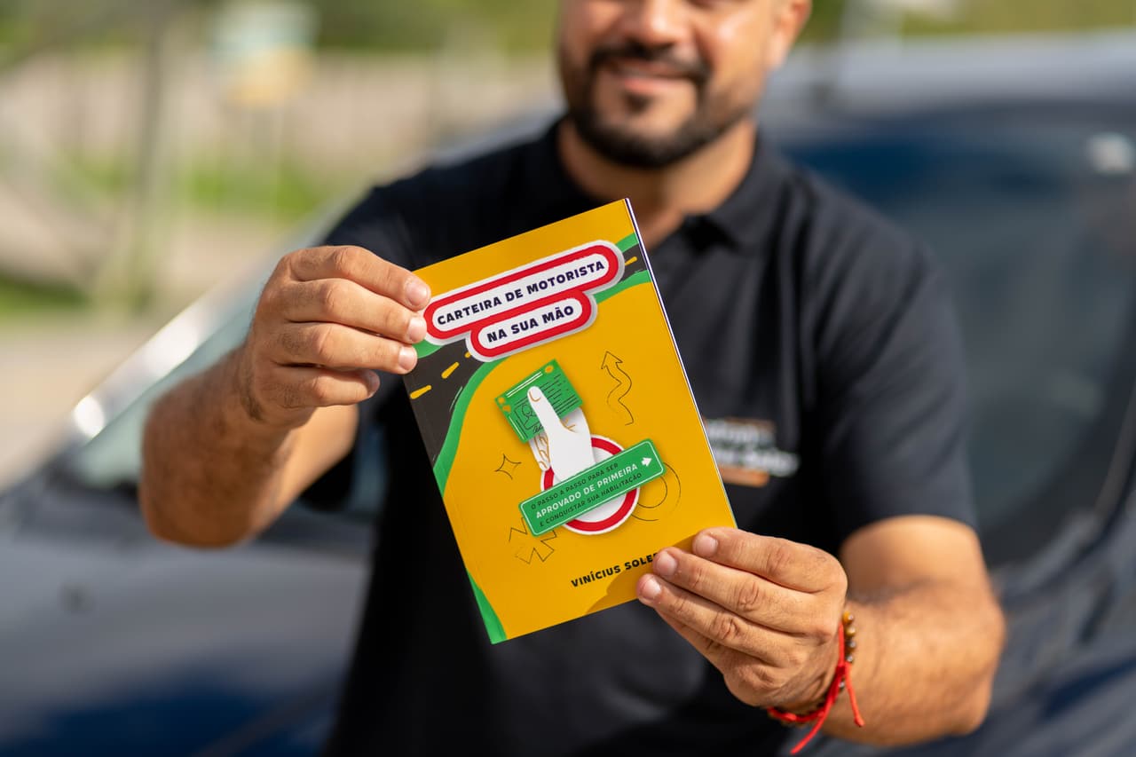 Vinícius Soler segurando o livro Carteira de Motorista na Sua Mão